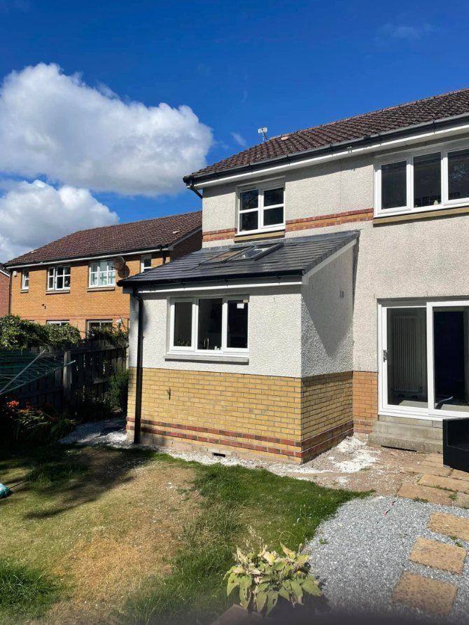 Single storey extension with a brick base, rendered walls and a tiled lean-to roof